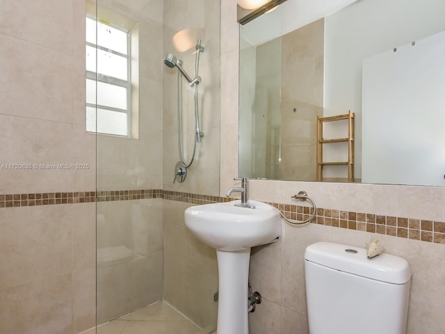 bathroom with toilet and a tile shower