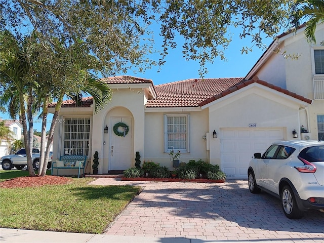 mediterranean / spanish house featuring a garage and a front yard