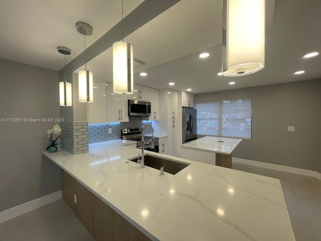 kitchen with decorative light fixtures, white cabinets, kitchen peninsula, and stainless steel appliances