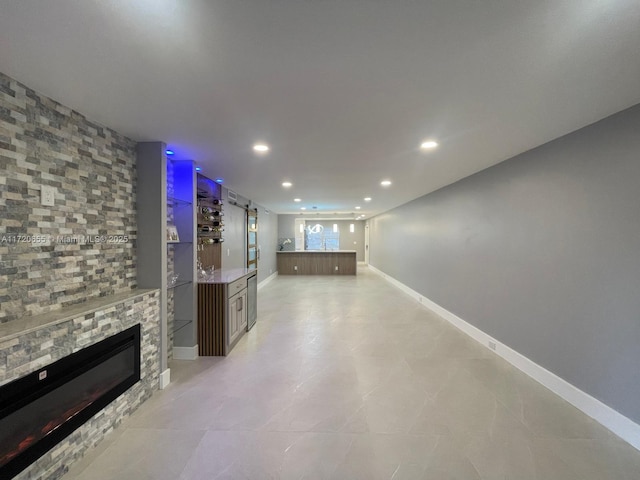 unfurnished living room featuring a stone fireplace