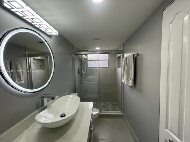 bathroom featuring toilet, a shower with door, and vanity