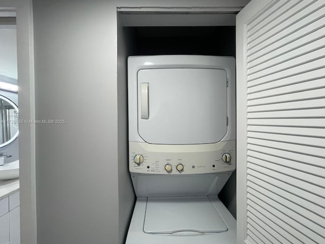 clothes washing area featuring stacked washer and clothes dryer