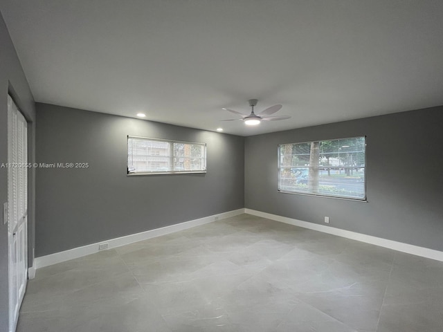 unfurnished room with ceiling fan and a wealth of natural light