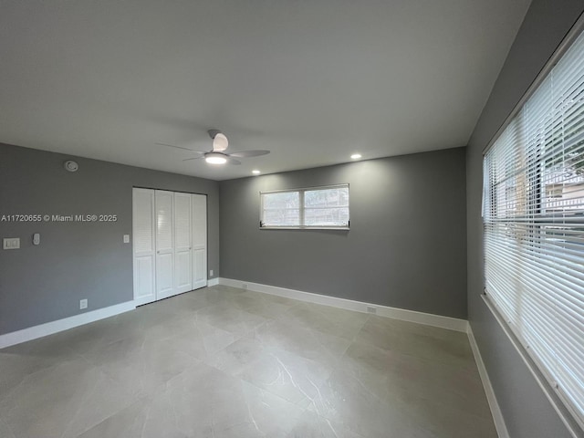 unfurnished bedroom with ceiling fan and a closet