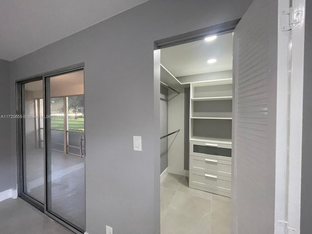 walk in closet with light tile patterned floors