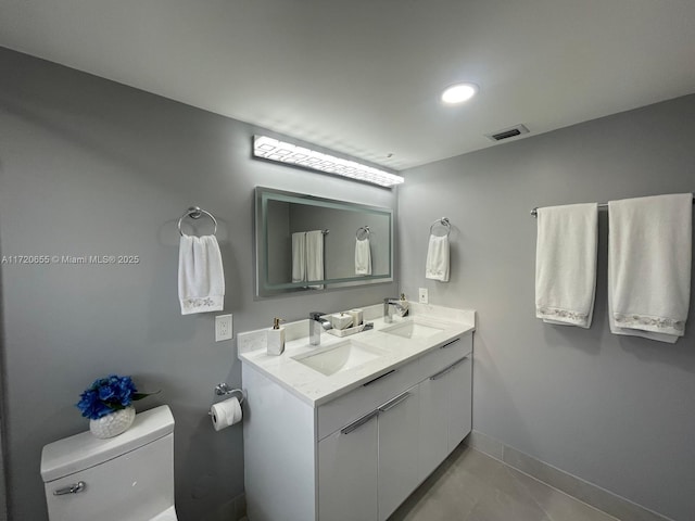 bathroom featuring toilet, vanity, and tile patterned flooring