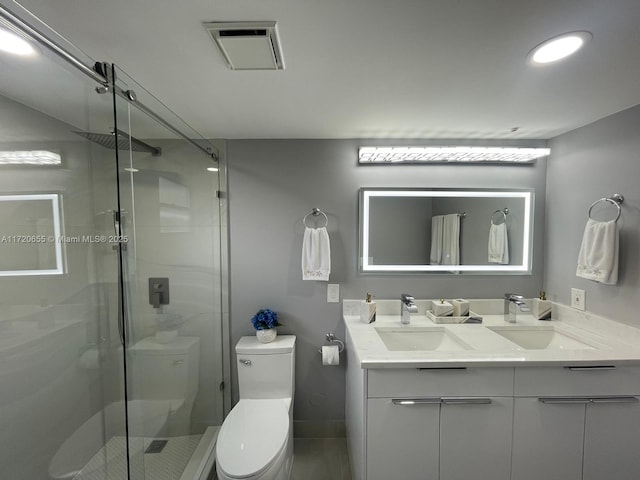 bathroom with toilet, a shower with door, and vanity