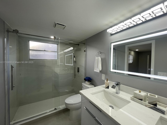 bathroom featuring toilet, tile patterned floors, walk in shower, and vanity