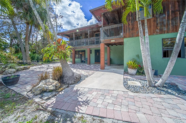 rear view of property featuring a patio and a balcony