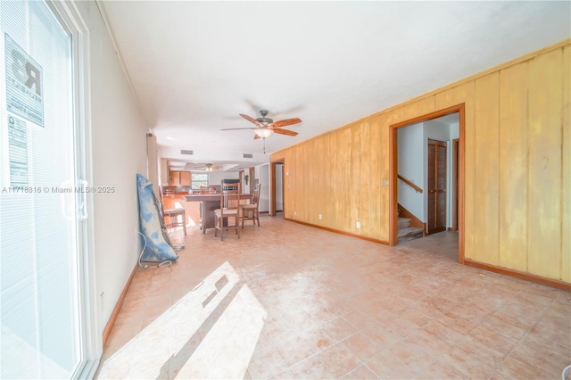 living room featuring wood walls and ceiling fan