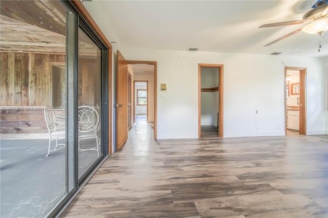 spare room with ceiling fan and wooden walls