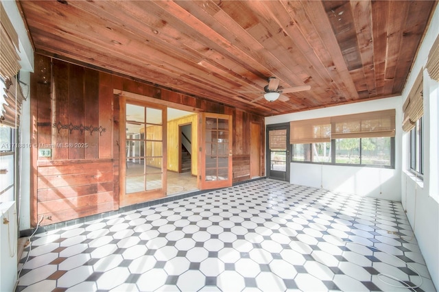 unfurnished sunroom featuring ceiling fan and wood ceiling