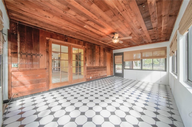 unfurnished sunroom with ceiling fan and wooden ceiling