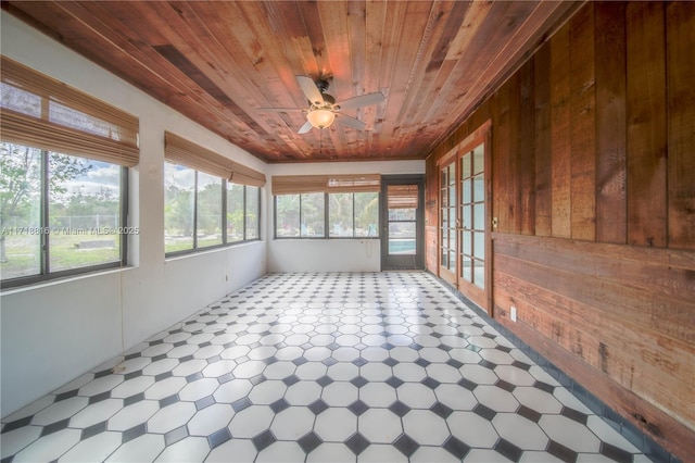 unfurnished sunroom featuring ceiling fan and wooden ceiling