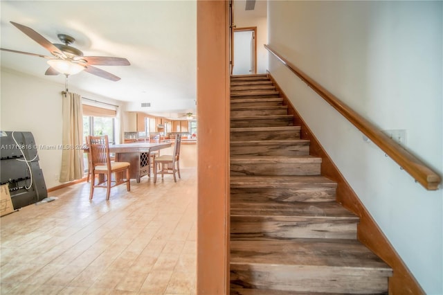 stairs with ceiling fan and hardwood / wood-style flooring