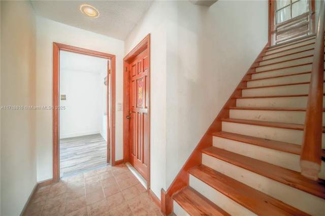 stairs with a textured ceiling