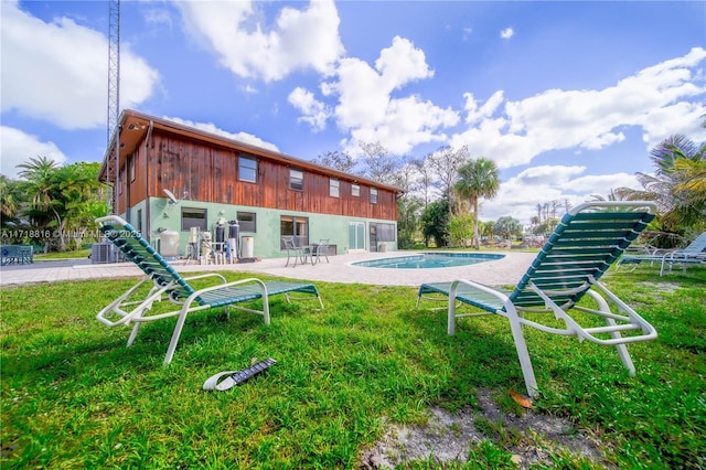 back of property with a patio, central AC unit, and a lawn