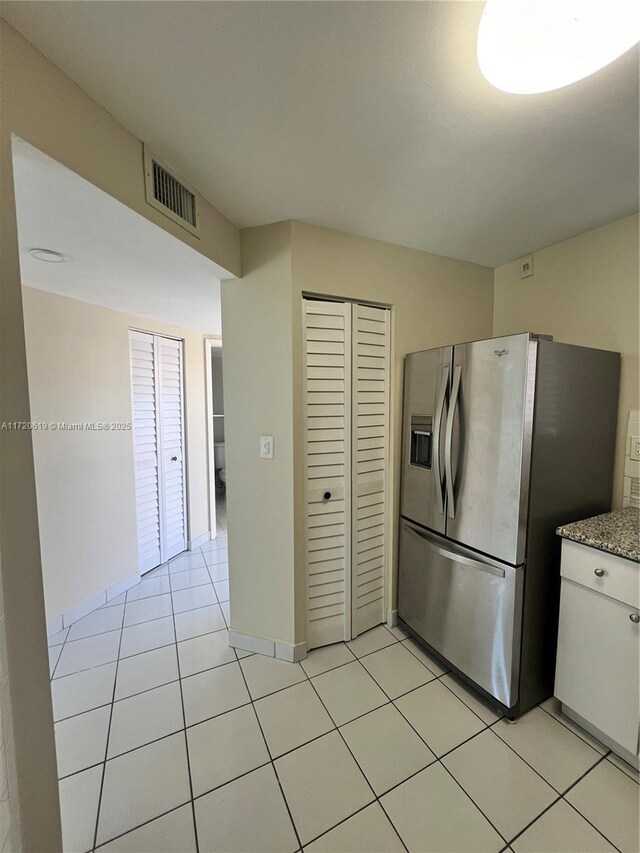 tiled spare room with ceiling fan