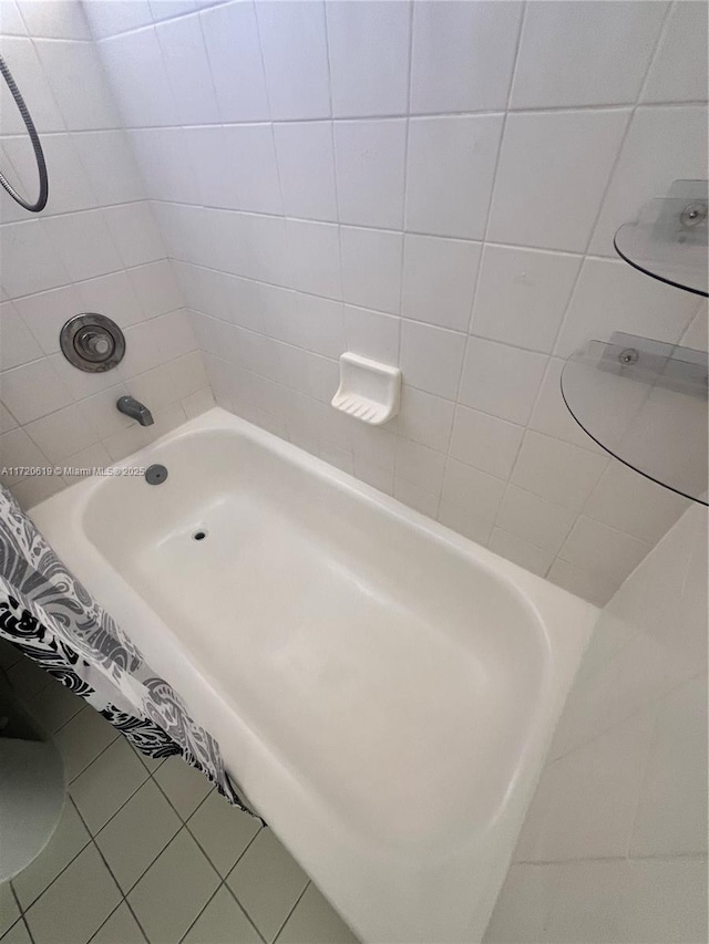 bathroom with tiled shower / bath and tile patterned flooring