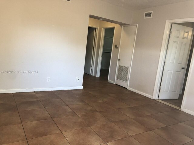 spare room featuring dark tile patterned floors