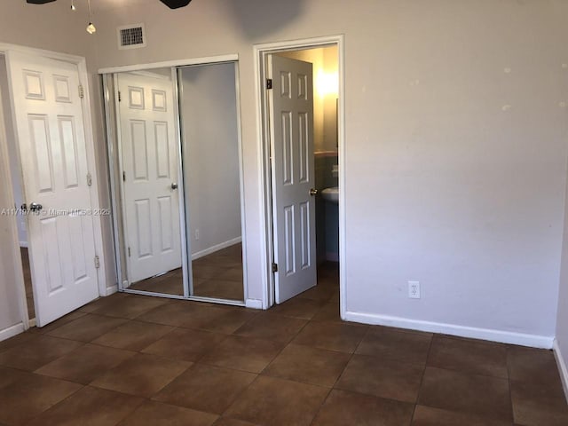 unfurnished bedroom with ceiling fan and a closet