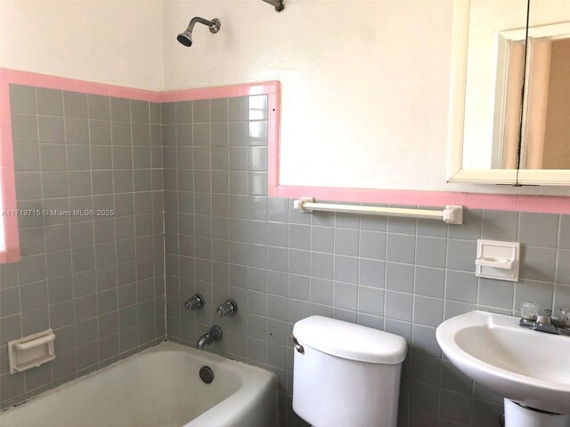 full bathroom with tiled shower / bath combo, toilet, sink, and tasteful backsplash