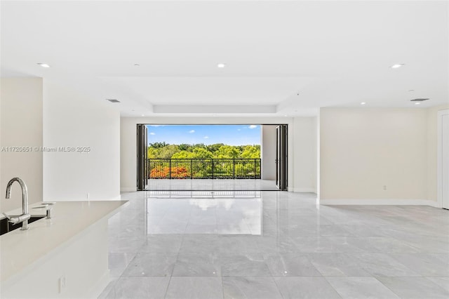 unfurnished living room with a tray ceiling