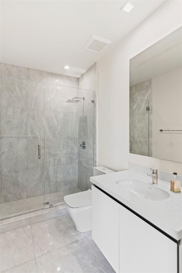 bathroom featuring an enclosed shower, vanity, and toilet