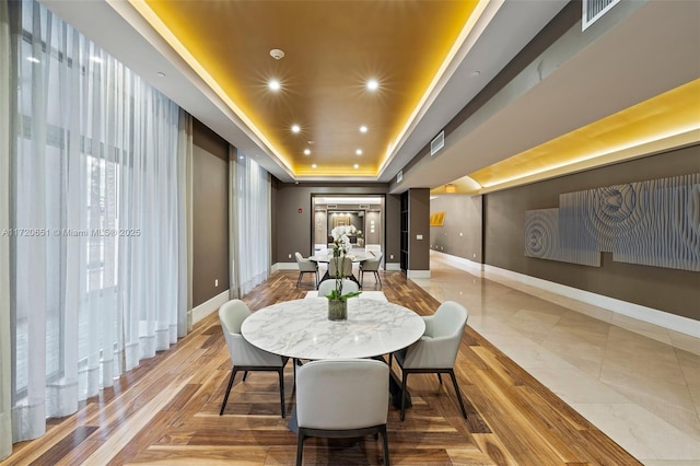 dining area with a raised ceiling