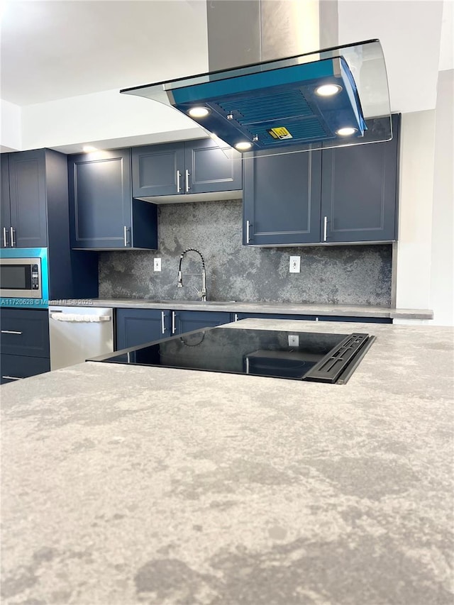 kitchen featuring appliances with stainless steel finishes, tasteful backsplash, ventilation hood, sink, and blue cabinetry