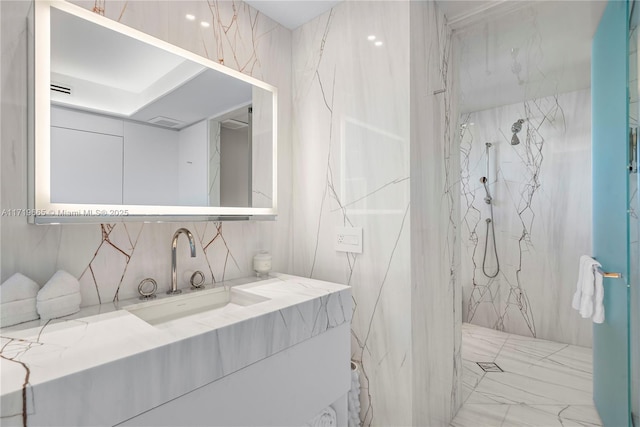 bathroom featuring a tile shower and vanity