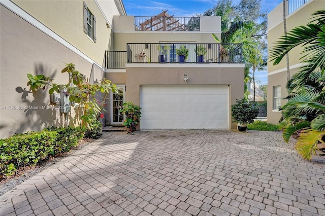 view of front facade with a garage, decorative driveway, and stucco siding