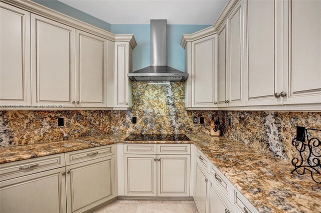 kitchen with wall chimney exhaust hood, tasteful backsplash, stainless steel appliances, and cream cabinets