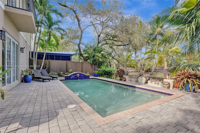 view of pool featuring french doors, a fenced in pool, a patio area, and fence