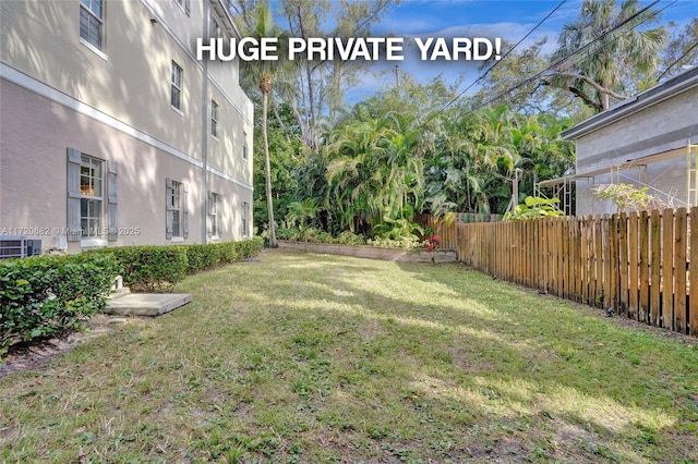 view of yard featuring central AC and fence