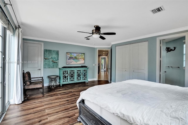 bedroom featuring hardwood / wood-style floors, ceiling fan, crown molding, and a closet