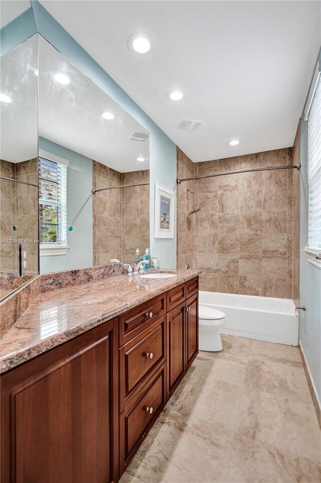 full bathroom with vanity, tiled shower / bath combo, and toilet