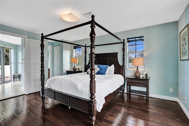 bedroom with multiple windows, french doors, dark hardwood / wood-style floors, and access to exterior