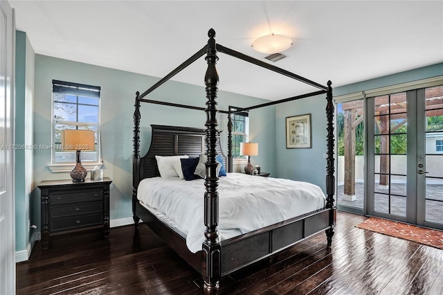bedroom with hardwood / wood-style floors, visible vents, and multiple windows