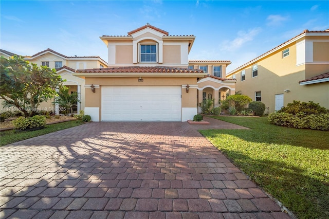 mediterranean / spanish-style home featuring a front yard and a garage