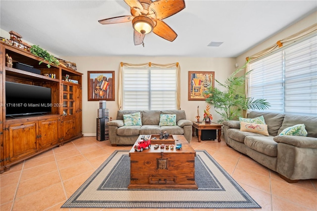 living room with ceiling fan, plenty of natural light, and light tile patterned floors