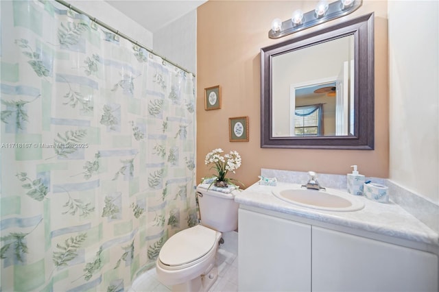 bathroom with toilet, vanity, and tile patterned flooring