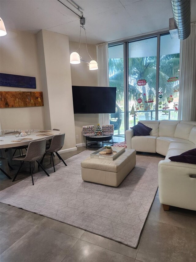 living room with a wall of windows and concrete floors