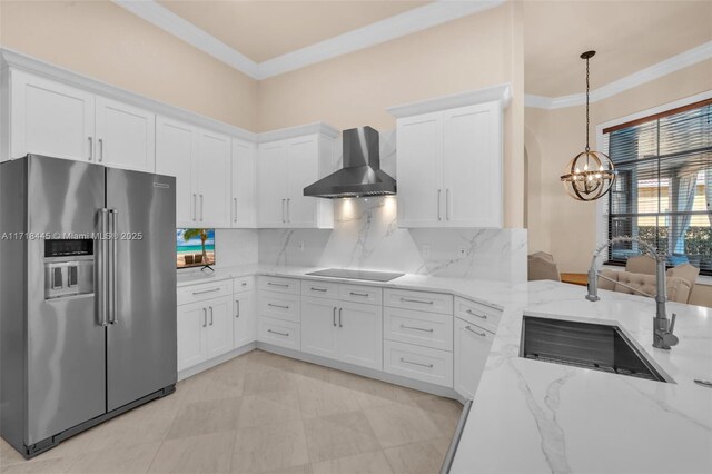 kitchen featuring decorative backsplash, high end refrigerator, white cabinetry, and wall chimney range hood