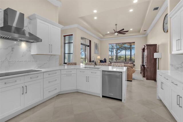 kitchen with dishwasher, wall chimney range hood, a raised ceiling, kitchen peninsula, and black electric cooktop