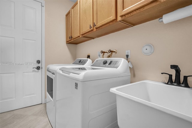 laundry room featuring cabinets, light tile patterned floors, separate washer and dryer, and sink