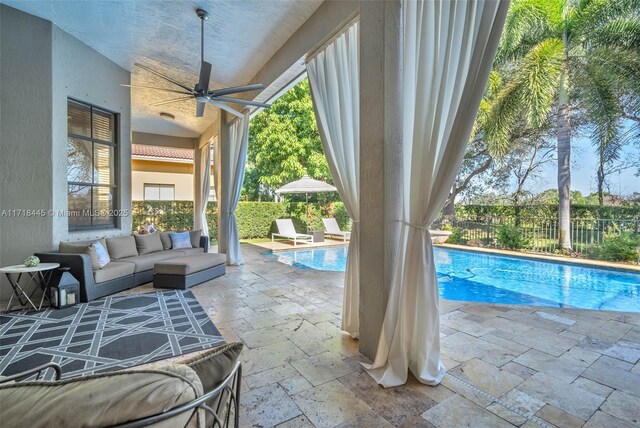 view of pool featuring ceiling fan, a patio, and an outdoor living space