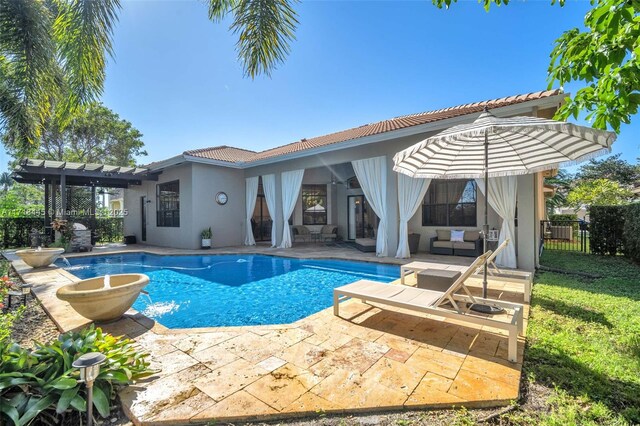 view of swimming pool with pool water feature and a patio