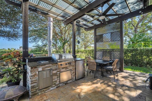 view of patio / terrace featuring grilling area, ceiling fan, and an outdoor kitchen