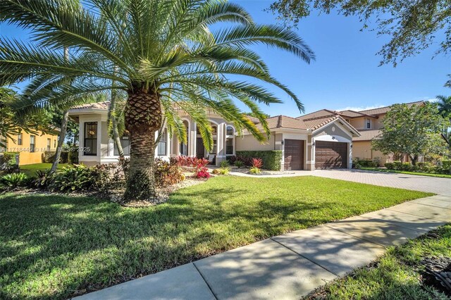 mediterranean / spanish house with a front yard and a garage